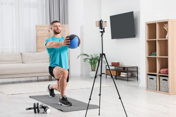 Trainer with ball streaming online workout on phone at home