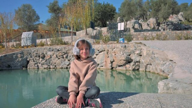 Happy girl sitting near the lake and relaxing. 4k footage UHD 3840x2160 