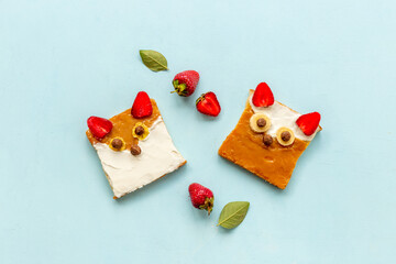 Funny kids sandwich in shape of fox face made from cream cheese and strawberries