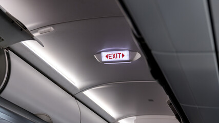 Exit sign in passenger airplane. Emergency exit sign on airplane. Exit airplane sign	 - obrazy, fototapety, plakaty
