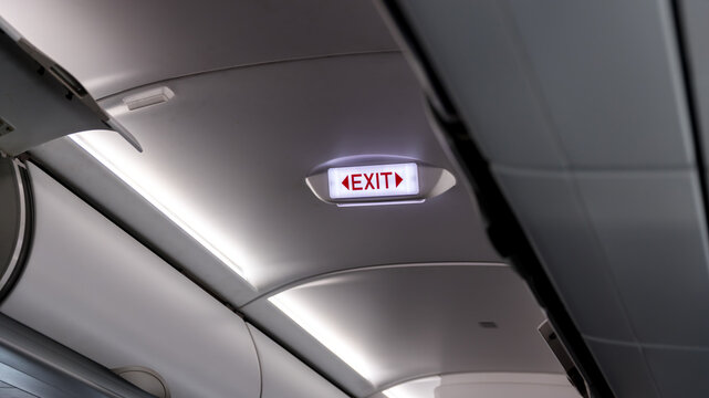 Exit sign in passenger airplane. Emergency exit sign on airplane. Exit airplane sign	
