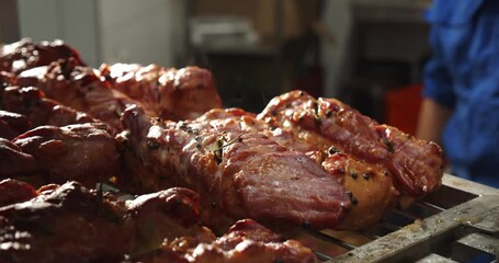 Worker takes the baked meat out of the oven and places it baking sheet to cool 