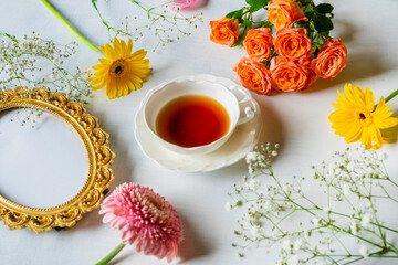 金のフォトフレームと暖色系の花