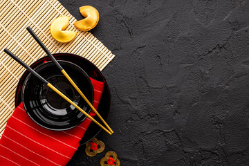 Asian style tabble place setting with fortune cookies and golden chopsticks