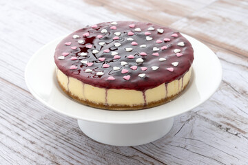 Blueberry cheesecake decorated with sweet hearts on wooden table