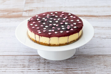 Blueberry cheesecake decorated with sweet hearts on wooden table