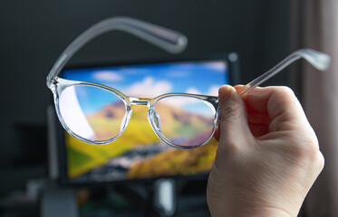 Selective focus on transparent clear blue light computer glasses and computer screen glowing on the...