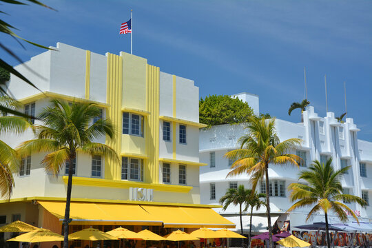 Miami Beach, USA - April 1, 2017 : Art Deco style pastel buildings architecture landmark in Miami Beach, South Beach, palm trees and blue sky.