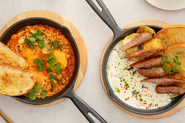 Top view on two pan dishes with sausages and eggs