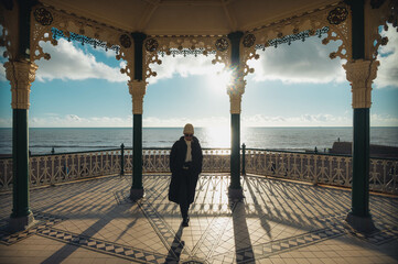 Brighton and Hove England, The Bandstand, opened 1884, Designed by Phillip Lockwood, with blue sky and clouds with an adult female person silhouette