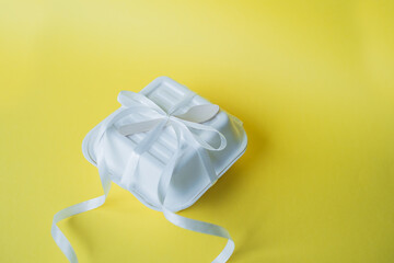 A bento cake box with a wooden spoon stands closed on a yellow background