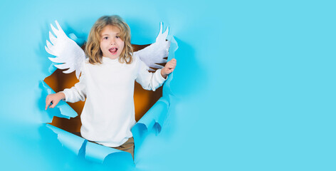 Child angel in paper hole. Cute kid with angelic wings. Valentines day concept. Valentine banner.