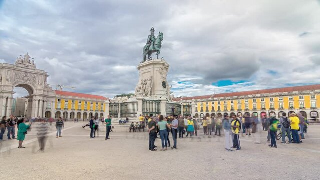 Bronze statue of King Jose I and triumphal arch at Rua Augusta at Commerce square timelapse hyperlapse in Lisbon, Portugal. Cloudy sky. Walking area