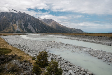 Hooker River flowing towards the Tasman River near Mount Cook in the South Island of New Zealand with mountains in the background