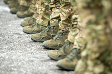 Army boots, close-up. Soldiers stand in a row, army shoes. Soldier, commando standing, ready for combat training. Military fashion. Army parade - a march of soldiers in uniform. - obrazy, fototapety, plakaty
