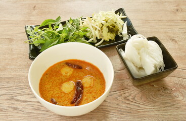rice noodles on bowl with spicy  fish curry sauce and fresh vegetable
