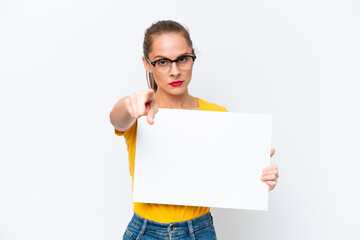 Young caucasian woman isolated on white background holding an empty placard and pointing to the front