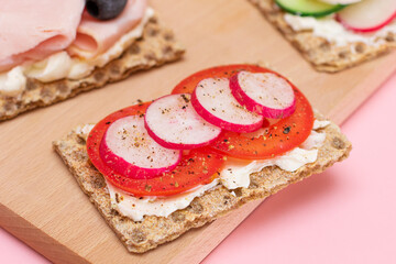 Different Whole Grain Crispbread with Ham, Tomato, Radish, Cucumber and Cheese. Easy Breakfast. Diet Food. Quick and Healthy Sandwiches. Crispbread with Tasty Filling. Healthy Dietary Snack