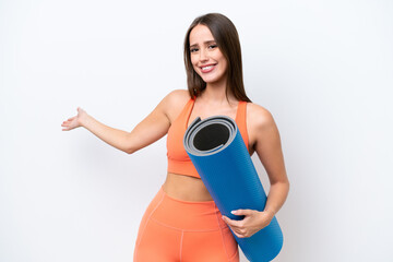 Young beautiful sport woman going to yoga classes while holding a mat isolated on white background...
