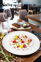 Octopus carpaccio. Spinach cream, cherry tomatoes. Delicious healthy Italian traditional food closeup served for lunch in modern gourmet cuisine restaurant