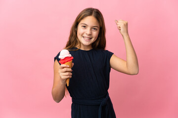 Child with a cornet ice cream over isolated pink background celebrating a victory
