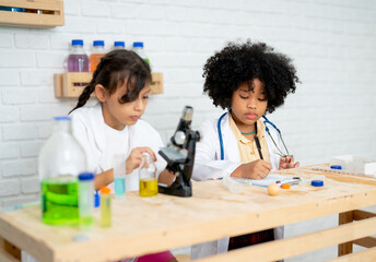 Asian young girl work with chemical and her friend also record the data from experiment in science class for young student at school.