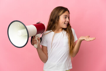 Child over isolated pink background holding a megaphone and with surprise facial expression