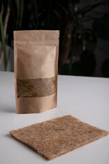 A paper bag with seeds for planting. A mat for growing microgreens.