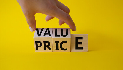 Value and Price symbol. Businessman Hand turns cubes and changes word Price to Value. Beautiful...