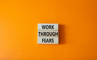 Work through fears symbol. Wooden blocks with words Work through fears. Beautiful orange background. Business and Work through fears concept. Copy space.