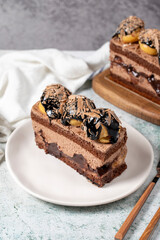 Chocolate and profiteroles cake. Layered cake with chocolate and cream on plate on stone background. close up