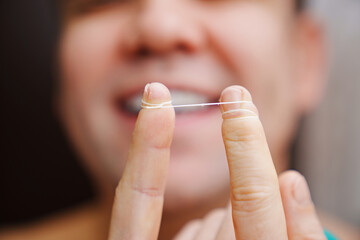 selective focus. a man's mouth close-up. a man brush your teeth with dental floss. concept of hygiene and health of teeth and oral cavity. daily care and brushing of teeth.