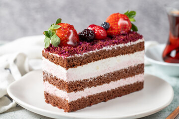 Fruit and whipped cream cake. Layered cake with forest fruit and cream on the plate. close up