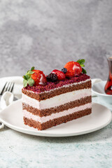 Fruit and whipped cream cake. Layered cake with forest fruit and cream on the plate. close up