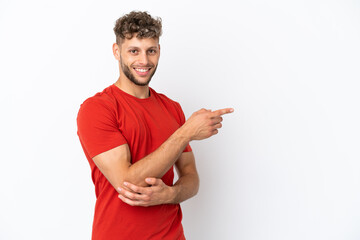 Young caucasian handsome man isolated on white background pointing finger to the side