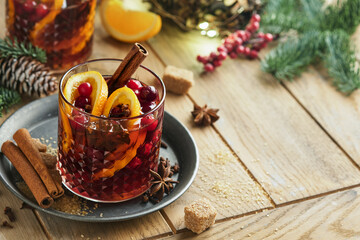 Christmas hot mulled wine. Glasses of mulled wine with aromatic spices cinnamon, anise, sugar and fir tree branches with bokeh and decorations. Traditional Xmas festive drink. Winter Christmas drink.