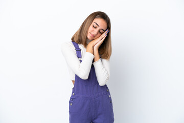 Fototapeta premium Young caucasian woman isolated on white background making sleep gesture in dorable expression