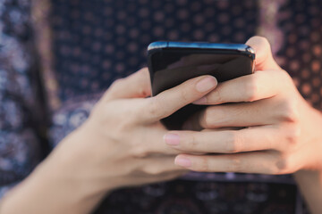 Selective focus on Young woman hand while using a mobile phone by texting the message to communicate with someone, copy space