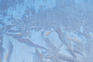 Frozen window, frost drawing on glass in cold winter