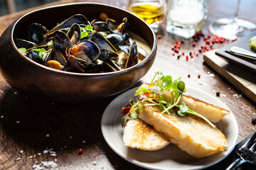 Blue mussels in cream wine sauce. Delicious healthy Italian traditional food closeup served for lunch in modern gourmet cuisine restaurant