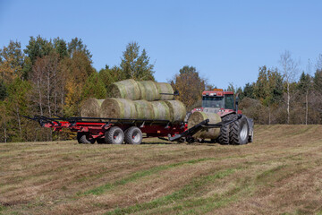 Collecting bales of hay with a self-loading hay trailer. Hay trailer. Hay collecting.  Auto loader trailer. Agriculture. Agricultural equipment. Auto-load bale handler. 