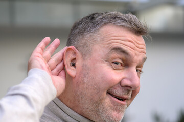 Middle age man has a hearing aid