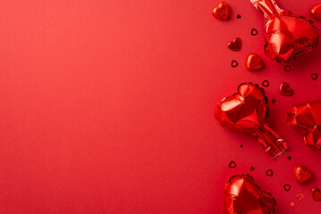 Saint Valentine's Day concept. Top view photo of heart shaped balloons candies and confetti on isolated red background with copyspace