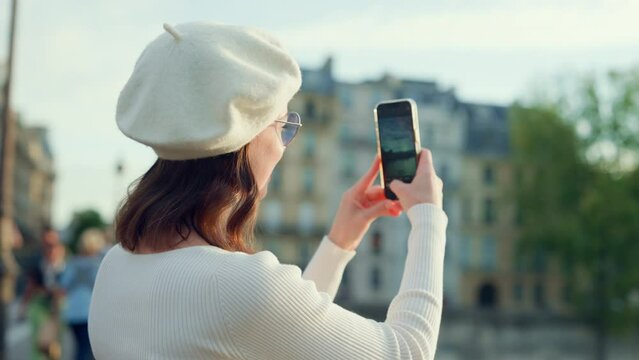 Attractive girl taking pictures of the city on a smartphone