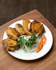 Fried chicken fillet cut into pieces with side dish of vegetables. Portion of dish on plate on wooden table. Serving dish. Photo for restaurant menu. Soft focus. Top view. 