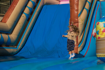 little girl having fun and sliding and jumping on outdoor playground. Kids Enjoying