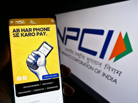 Stuttgart, Germany - 01-16-2023: Person holding cellphone with website of National Payments Corporation of India (NPCI) on screen with logo. Focus on center of phone display.