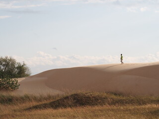Obraz na płótnie Canvas person walking in the sand dunes