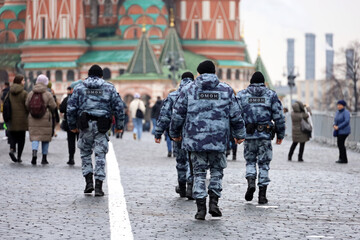 Russian riot police walking down the Red square in Moscow on background of St. Basil's Cathedral