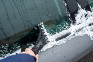 Scraping the car window with a scraper from ice and snow. The concept of freezing windows, getting...